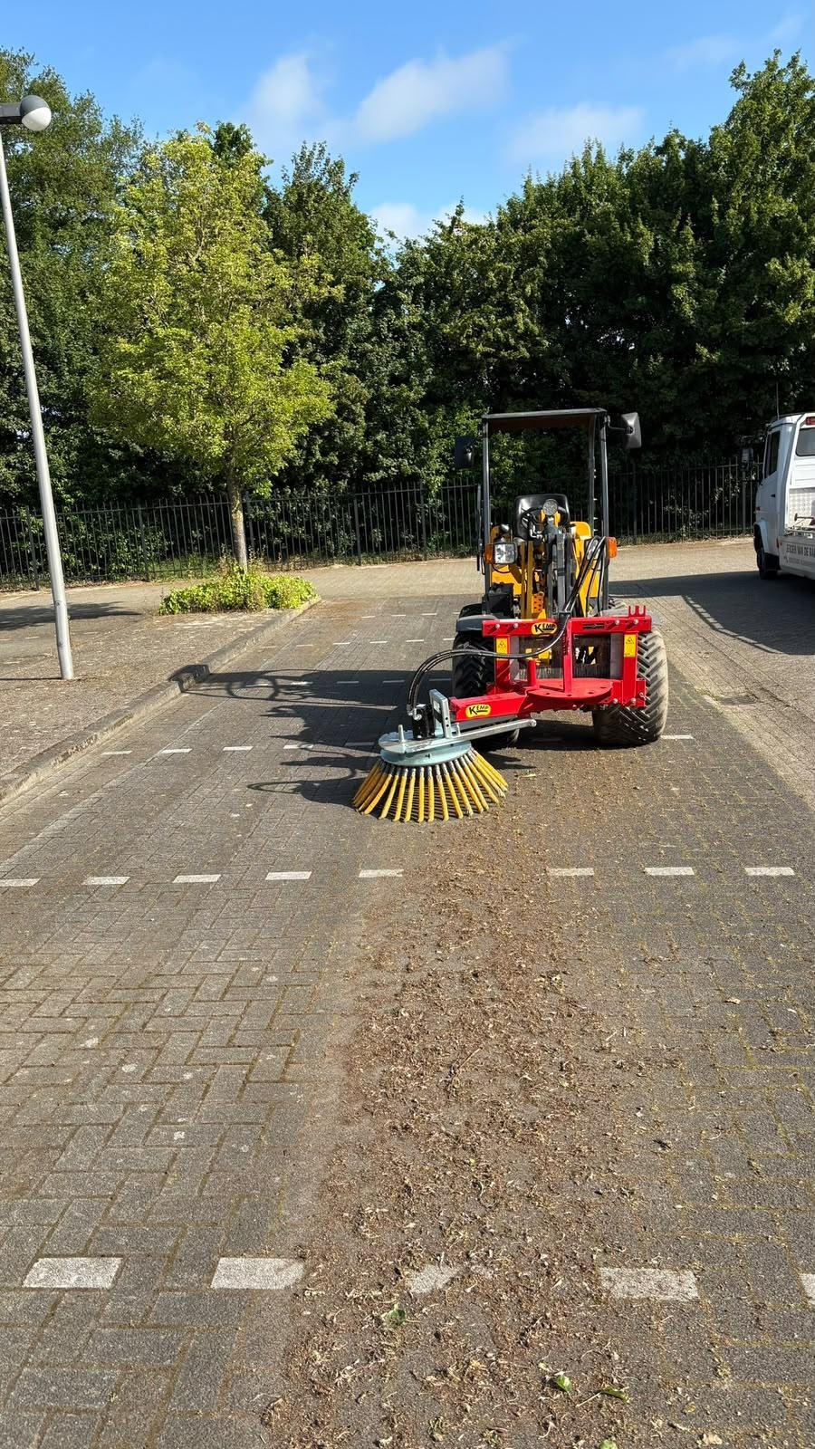 Van de Rakt onkruidborstel veegt mechanisch onkruid van een bestrate parkeerplaats